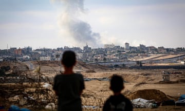 Boys watch smoke billowing during Israeli strikes east of Rafah in the southern Gaza Strip. Follow for latest live updates.