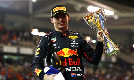 Max Verstappen celebrates with the trophy after winning his first F1 drivers’ title in extraordinary fashion.