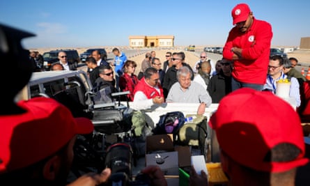 António Guterres, surrounded by people, looking at the contents of the back of a lorry.