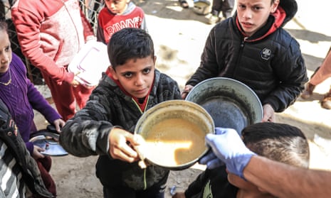 Volunteers of World Central Kitchen hand out food to Palestinian children in the mobile kitchens they have brought to Rafah, Gaza.