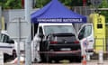 a forensic checks a black car which is being guarded by French gendarme after a ramming attack