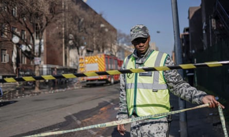 A security guard cordons off a street at the scene.