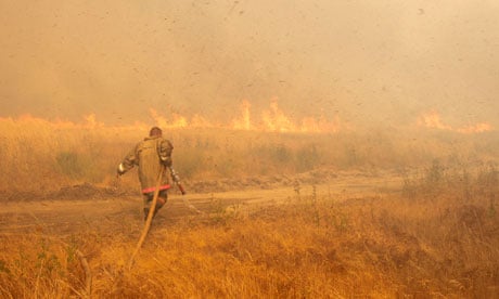 A firefighter works to extinguish a wildfire outside the settlement of Kustarevka in Ryazan region