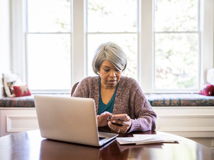 Older woman sitting at a table with a laptop