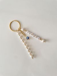 Personalized Pearl Key Chains - Custom Evil Eye Keyring This stylish keychain is made of faux pearl beads and an evil eye bead. -Perfect Gift- These key rings are nice gift choices for friends, lovers, mothers, girlfriends and wives, especially on Valentine's Day, Mother's Day, birthdays, Thanksgiving, Christmas or New year etc. they will be very happy to receive such exquisite gifts. -HOW TO ORDER-  1-Add personalization in the personification box. -PACKAGING- Each order comes with a lovely gift box.  -SHIPPING- This item ships within 2-5 business days; from then the estimated delivery to the USA is an additional 7-12 business days. (Standard Shipping) I offer free shipping on orders over $35 for the US customers. Please feel free to contact with any questions or custom orders. Thanks for