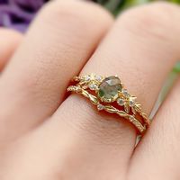 Indulge in the free-spirited charm of our Wildflower Moss Agate Ring. This beauty showcases a rose-cut oval moss agate gemstone nestled in an exquisite leafy band with white topaz accents. An alluring piece that embodies the carefree beauty of nature's most captivating blooms. So, dance in the sun, chase your dreams, and let this ring be your guiding light along the way. ✦ Available in both 14K yellow gold vermeil (14K yellow gold plated over a sterling silver base) and 10K solid yellow gold.