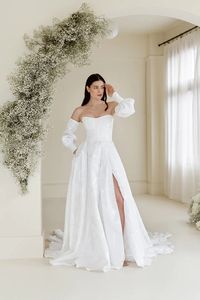 curved strapless wedding gown || full jacquard with boning wedding gown || pocketed slit skirt weddin gown || button-cuff puff sleeves || modern wedding dress