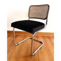 A vintage modern black Cesca style chair that has been restored. The cane back chair is in the Marcel Breuer style and has had a new seat makeover using a black velvet chevron fabric. Often used as a desk chair or single side chair for your living area, it can be highly versatile. Note - The seat sits slightly higher than a regular chair.