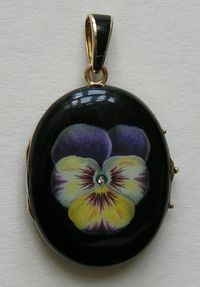 An early Victorian gold locket is most likely a mourning piece.  The pansy is beautifully enameled in shades of lavender and yellow and is accented with a tine old min cut diamond center.  The back and matching bale are enameled in black.  The locket measures 1 1/4 inches by 1 inch and the bale add another 3/8ths of an inch for a total length of just under 1 3/4 inches.  The locket is unmarked (not unusual for this period)
