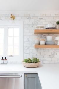pale grey cabinets, marble subway tile, brass sconces, floating shelves in wood