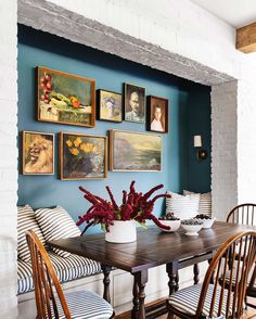a dining room with blue walls and pictures on the wall