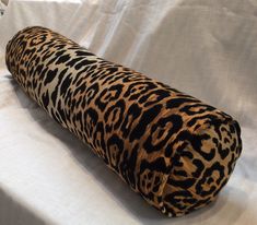 an animal print pillow sitting on top of a white sheet