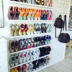 there are many pairs of shoes hanging on the wall next to each other in this shoe rack
