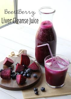 beet berry liver cleanse juice in a glass next to sliced beets and blueberries