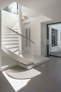 a white staircase in an empty room with glass doors