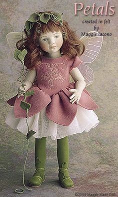 a doll with red hair wearing a pink dress and green boots
