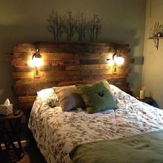 a bed with two lights on the headboard above it and pillows on the bottom