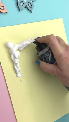 someone is painting the bottom part of a piece of paper with white paint on it