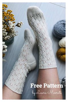 a woman's legs with white socks and crocheted socks next to flowers