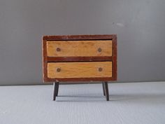 a small wooden table with two drawers on it