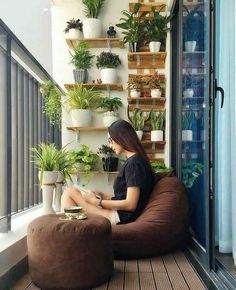 a woman sitting on a bean bag chair with potted plants