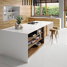 a modern kitchen with white counter tops and wooden accents, along with an island in the center