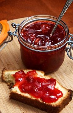 a piece of bread with jelly on it and a jar of jam in the background