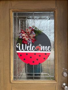 a welcome sign on the front door of a house with a ladybug theme