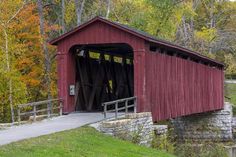 a red covered bridge crossing over a river