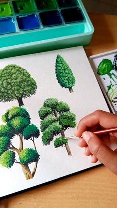 someone is drawing trees with colored pencils