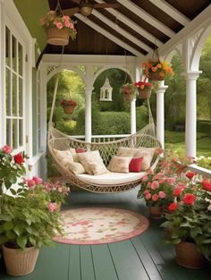 a porch with hammock, potted plants and flowers
