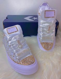 a pair of white and gold high top sneakers with crystal embellishments on them