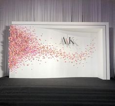 an artistic display with pink and white confetti on the wall in front of it