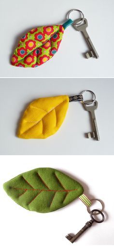 three different key fobs are shown on the same white surface, one has a green leaf and the other is a yellow leaf