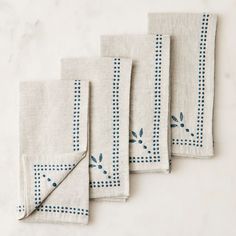 four napkins with blue and white designs on them