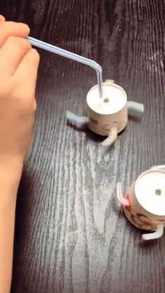two teapots sitting on top of a table with blue and white straws