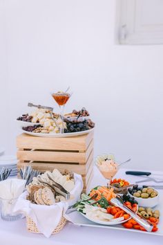 a table topped with lots of different types of food and wine glasses on top of it