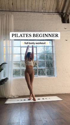 a woman standing on a yoga mat in front of a window with the words pilates beginner above her