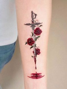 a woman's arm with a rose and dagger tattoo on it