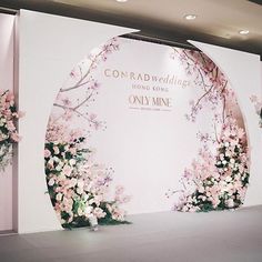 the backdrop is decorated with pink flowers and greenery