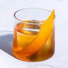 an orange slice sitting on top of a glass filled with liquid