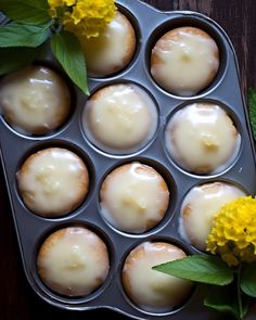 some cupcakes are in a muffin tin with yellow flowers on the side