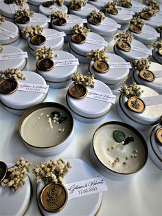 wedding favors are arranged on white plates with gold trimmings and flowers in them