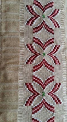 a close up of a piece of cloth with red and white designs on it's side