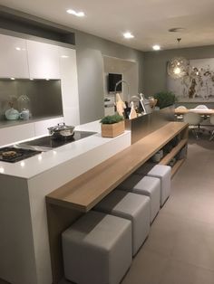 a kitchen with an island and stools next to the counter top in front of it
