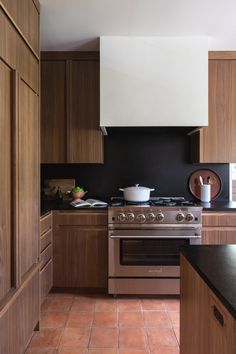 a kitchen with an oven, stove and counter tops in wood grained finish cabinets