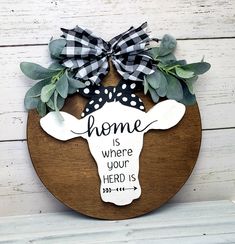 a wooden sign that says home is where your herd is