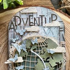 a wooden plaque with the word adventure written on it and some butterflies flying over it