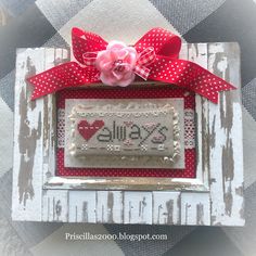 an altered picture frame with a red bow on it