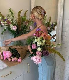 a woman standing in front of a counter with flowers